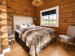 a bedroom with a bed and two chairs and a window at Dream mountain cabin with jacuzzi and views in Gol +45 photos