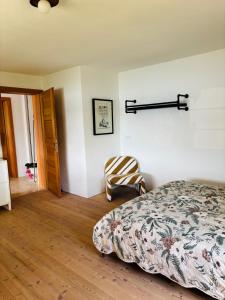 a bedroom with a bed and a chair in it at See Apartment Traunsteinstrasse in Gmunden