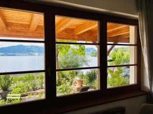a room with a window with a view of a lake at See Apartment Traunsteinstrasse in Gmunden +7 photos