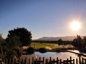 a view of a pond with the sun in the sky at Linnaeus Farm, Berry - by Linnaeus Collection in Berry