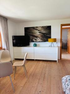 a living room with a television and a white cabinet at See Apartment Traunsteinstrasse in Gmunden