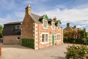an old brick house with a green door at Bosta Guest House - Private Rooms - Inverness in Inverness