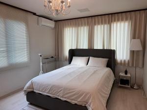 a bedroom with a large bed and a chandelier at 차북차북 in Kwakchi-ri