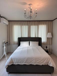 a bedroom with a large bed with a chandelier at 차북차북 in Kwakchi-ri