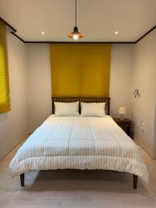 a bedroom with a large bed with a yellow wall at 차북차북 in Kwakchi-ri