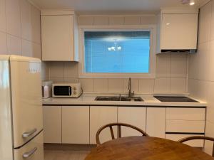 a kitchen with white cabinets and a table and a window at 차북차북 in Kwakchi-ri +10 photos