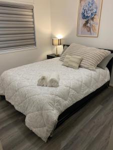 a bedroom with a large bed with towels on it at Casa Bliss in Springfield Lakes