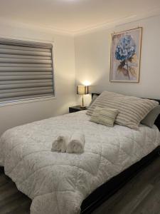 a bedroom with a large bed with towels on it at Casa Bliss in Springfield Lakes