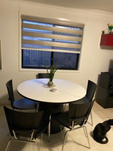 a table and chairs in a room with a window at Casa Bliss in Springfield Lakes