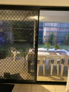 a dog sitting at a table behind a fence at Casa Bliss in Springfield Lakes