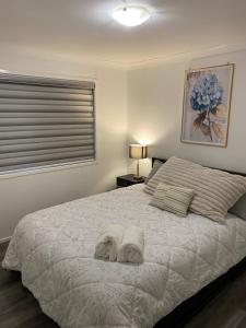a bedroom with a bed with two towels on it at Casa Bliss in Springfield Lakes