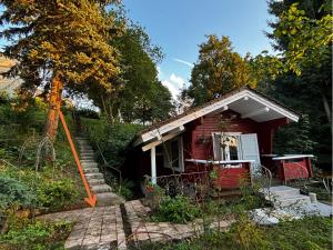 a small red house with a porch and stairs at Seesen Private Lodge in Seesen