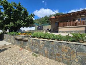 a stone retaining wall in front of a house at Seosko domaćinstvo Trajković in Mladenovac
