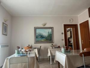a dining room with two tables and a painting on the wall at B&B Altea in Pescara