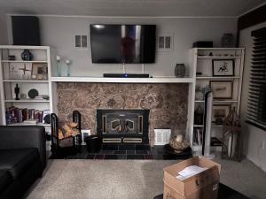 a living room with a fireplace with a television above it at Peaceful in Evergreen