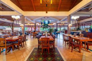 an empty restaurant with wooden tables and chairs at Chanalai Garden Resort, Kata Beach in Kata Beach