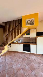 a kitchen with white cabinets and a staircase at IL PICCOLO PARADISO in San Massimo
