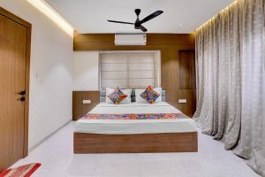 a bedroom with a bed and a ceiling fan at FabHotel Vaishnav Bairagi in Nashik