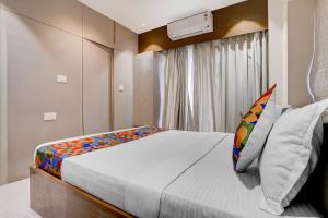 a bedroom with a large bed and a window at FabHotel Vaishnav Bairagi in Nashik