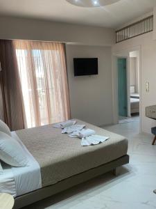 a bedroom with a bed with towels on it at Sirena Apartments in Agia Pelagia +43 photos