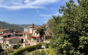 a village on a hill with houses and trees at La Matrice in Garlenda