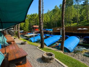 a group of blue lounges and boats on a river at Batupineus Riverside in Palayangan