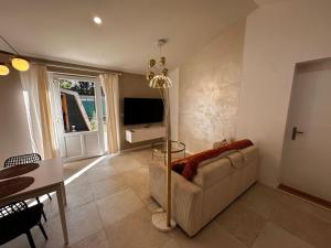 a living room with a couch and a television at White housse - cabane - Sèvre Niortaise in Niort
