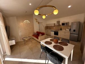 a kitchen and living room with a table and chairs at White housse - cabane - Sèvre Niortaise in Niort