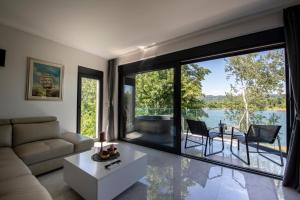 a living room with a couch and a large window at Vila Dominus Lux in Veliko Gradište