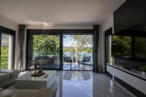 a living room with a tub and large windows at Vila Dominus Lux in Veliko Gradište