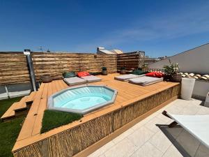 ein Whirlpool auf einer Holzterrasse in der Unterkunft Yllen Rooms in Avola