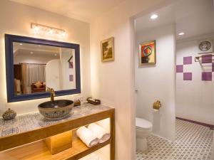 a bathroom with a sink and a toilet and a mirror at The Moon Rabbit Resort Pai in Pai