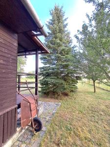 a wheelbarrow sitting on the side of a house at Kemp pro karavan a stan s chatkou in Veselí nad Moravou +8 photos