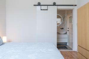 a bedroom with a bed and a bathroom with a sink at Zwaluwenburg 4 in 't Harde