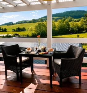 a table and chairs on a porch with a view at Auszeit Sauerland in Schmallenberg