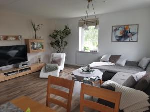 a living room with a couch and a tv at Auszeit Sauerland in Schmallenberg