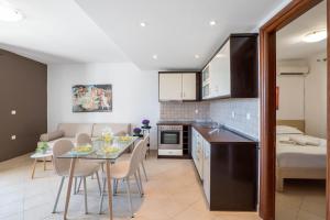 a kitchen and living room with a table and chairs at Corfu Dream Holidays Villas in Glyfada
