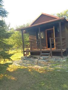 a small wooden cabin with a porch and a door at Kemp pro karavan a stan s chatkou in Veselí nad Moravou