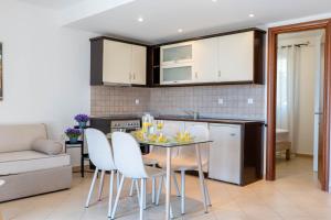 a kitchen and dining room with a table and chairs at Corfu Dream Holidays Villas in Glyfada