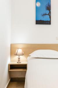 a bedroom with a bed and a nightstand with a lamp at Corfu Dream Holidays Villas in Glyfada +44 photos