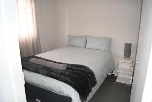 a small bed in a small room with a window at Chalet Steenbok in Ladismith