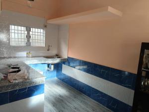 a kitchen with blue and white tiles on the wall at Ira's Abode in Dibrugarh