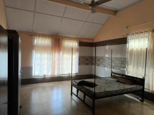 a bedroom with a bed in a room with windows at Ira's Abode in Dibrugarh
