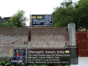 a brick wall with two signs on top of it at Ira's Abode in Dibrugarh