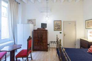 a room with a bed and a table and a refrigerator at Nel Cuore di Bologna M ,Bologna by Shortholidays in Bologna