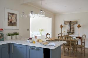 a kitchen with blue cabinets and a table with food on it at Meadow Drive in Bembridge