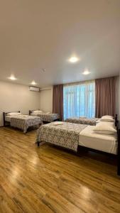 a bedroom with three beds and a large window at Hotel Nena in Kobuleti +25 photos