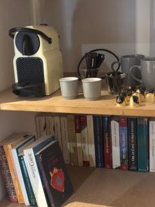 a book shelf with a toaster and some books at Maison agostini in Zonza