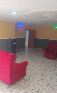 a living room with two red couches in a room at Monarch Apartment in Oshogbo