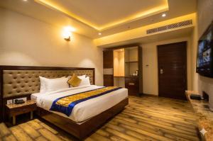 a hotel room with a bed and a flat screen tv at Hotel Everland Wish in Jaipur